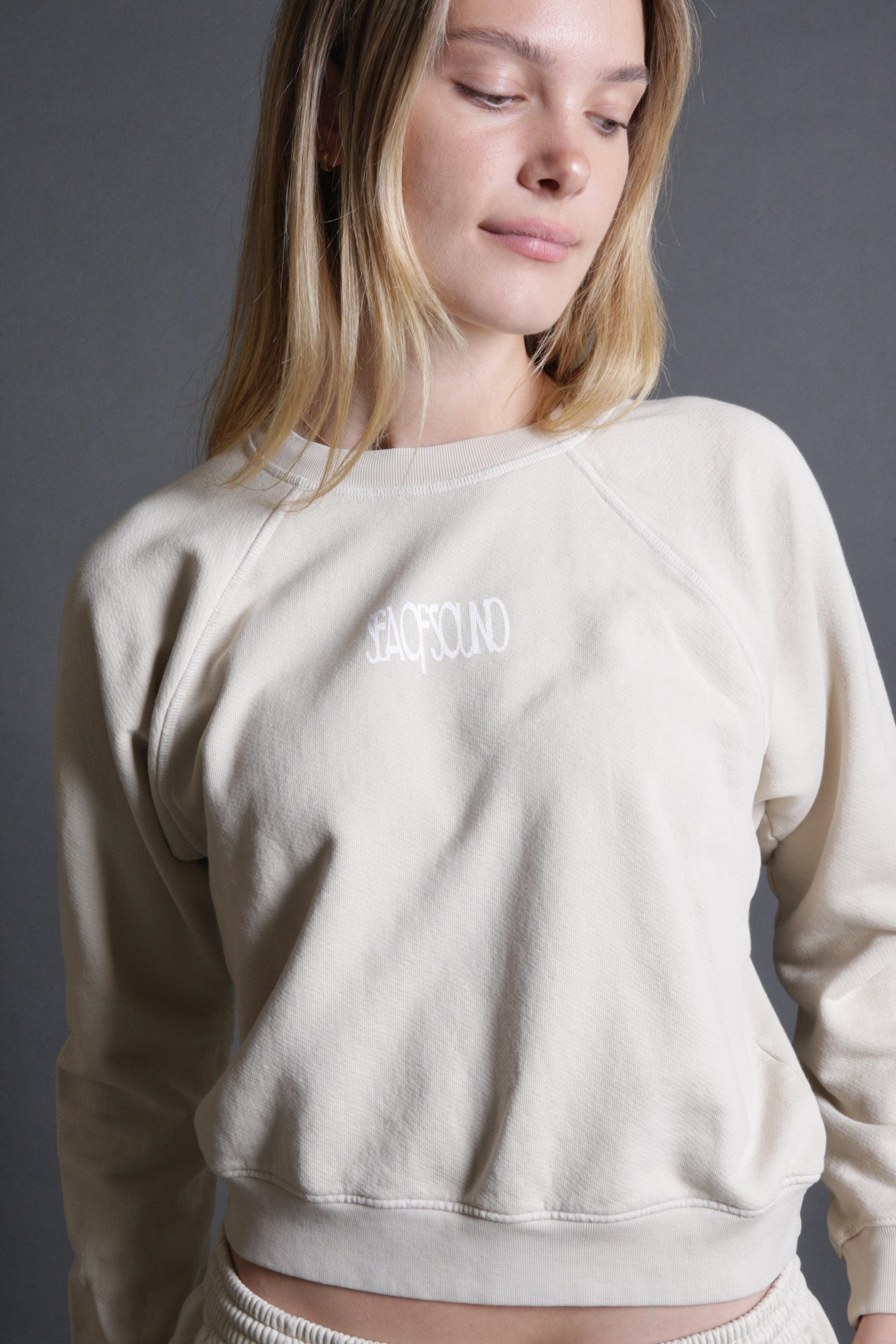 This model is wearing a crewneck in sand with the Sea Of Sound by Gavin Rossdale Sea Of Sound logo on the front