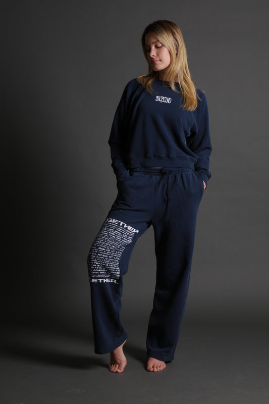 The model is wearing a navy lounge pant from Sea Of Sound by Gavin Rossdale with the Together logo on the left leg