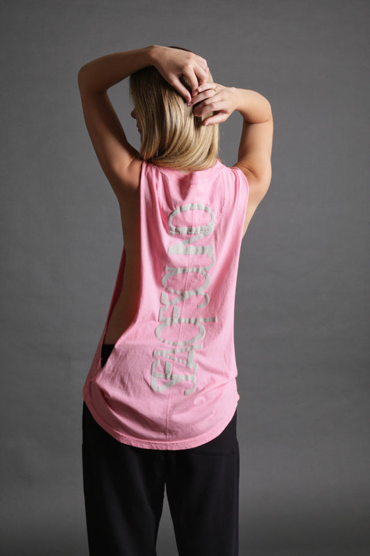 The model is wearing the stage tank in pink from Sea Of Sound by Gavin Rossdale with the main Sea Of Sound logo on the back placed vertically.
