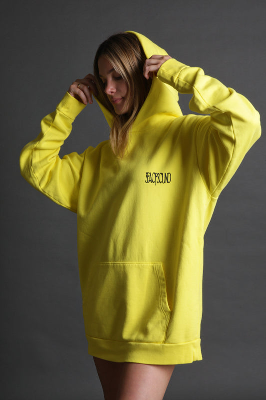 The model is wearing the yellow and black Righteous Hoodie from Sea Of Sound by Gavin Rossdale with the main Sea Of Sound logo on the front.