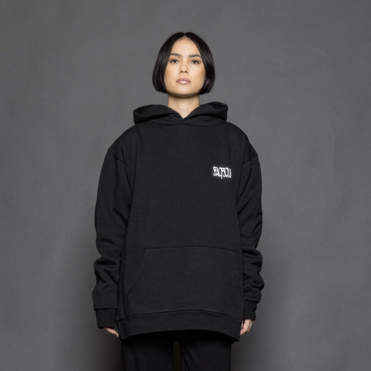 The model is wearing the black and white premium hoodie from Sea Of Sound by Gavin Rossdale with the main Sea Of Sound logo on the front.